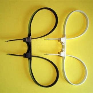 Two pairs of scissors, one black and one white, placed on a yellow surface.